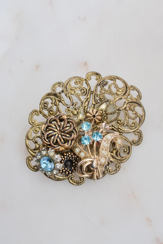 A vintage Art Nouveau brooch with intricate brass filigree