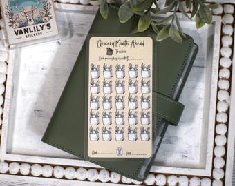 May include: A rectangular beige sticker sheet titled Grocery Month Ahead Tracker with a small grocery bag icon. It features a grid of twenty-five black and white grocery bag illustrations, with blank lines for goal and total tracking at the bottom.