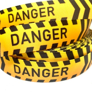 May include: Yellow and black striped ribbon with the word "DANGER" printed in black letters.