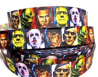May include: A black and white ribbon with a repeating pattern of colorful monster faces. The ribbon features a variety of monsters, including Frankenstein, Dracula, and the Creature from the Black Lagoon.