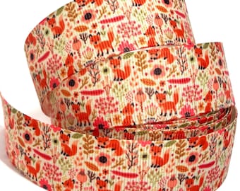May include: A roll of cream-colored grosgrain ribbon featuring a repeating pattern of small orange foxes, pink flowers, and brown foliage. The textured fabric ribbon displays a dense, colorful print of woodland animals and botanical elements.