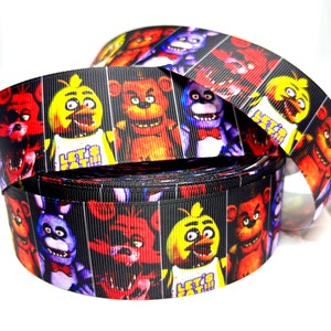 May include: Black and white ribbon featuring colourful cartoon characters from the video game Five Nights at Freddy's. The characters include Freddy Fazbear, Bonnie the Bunny, Chica the Chicken, and Foxy the Pirate Fox. The ribbon has the text "Let's Eat!" on it.