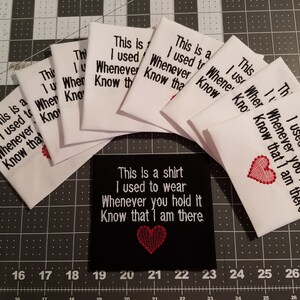 May include: A set of white fabric patches with the text "This is a shirt I used to wear Whenever you hold it Know that I am there."  A black fabric patch with the same text and a red heart.