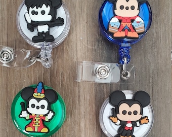 May include: Five different retractable badge holders with cartoon Mickey Mouse characters. Each holder has a clear plastic case with a colorful background and a different Mickey Mouse character. The characters include Mickey Mouse dressed as a chef, a musician, a painter, a construction worker, and a pirate.