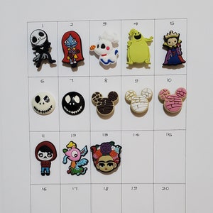 May include: A grid of 20 colorful cartoon character shoe charms. The charms are arranged in rows of five. The characters include Jack Skellington, Sally, a ghost, Oogie Boogie, Maleficent, Mickey Mouse, and more.