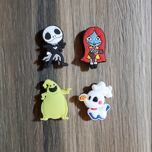May include: Four Nightmare Before Christmas character shoe charms. The charms are made of a soft, flexible material and feature Jack Skellington, Sally, Oogie Boogie, and Zero.