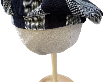 Cappello a righe bianche e nere con accenti di tela color salmone. Unico nel suo genere.