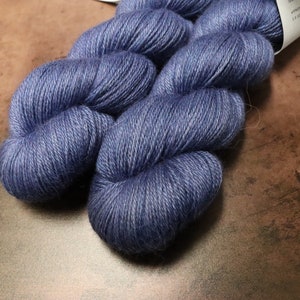May include: Two skeins of blue yarn, a soft and fuzzy texture, ready for knitting or crocheting.