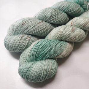 Hand Dyed KM Fingering Sock Yarn Superwash Merino Wool Nylon in Pale Green with Brown and Green Speckles