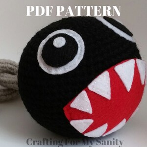 May include: A black and red felt plush toy shaped like a character from the video game Super Mario Bros. The toy has a large white eye and a red mouth with white teeth. The text "PDF PATTERN" is at the top of the image. The text "Crafting For My Sanity" is at the bottom of the image.