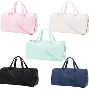 May include: Five different colored duffel bags. The bags are all the same style and size. The colors are pink, white, light blue, black, and navy blue.