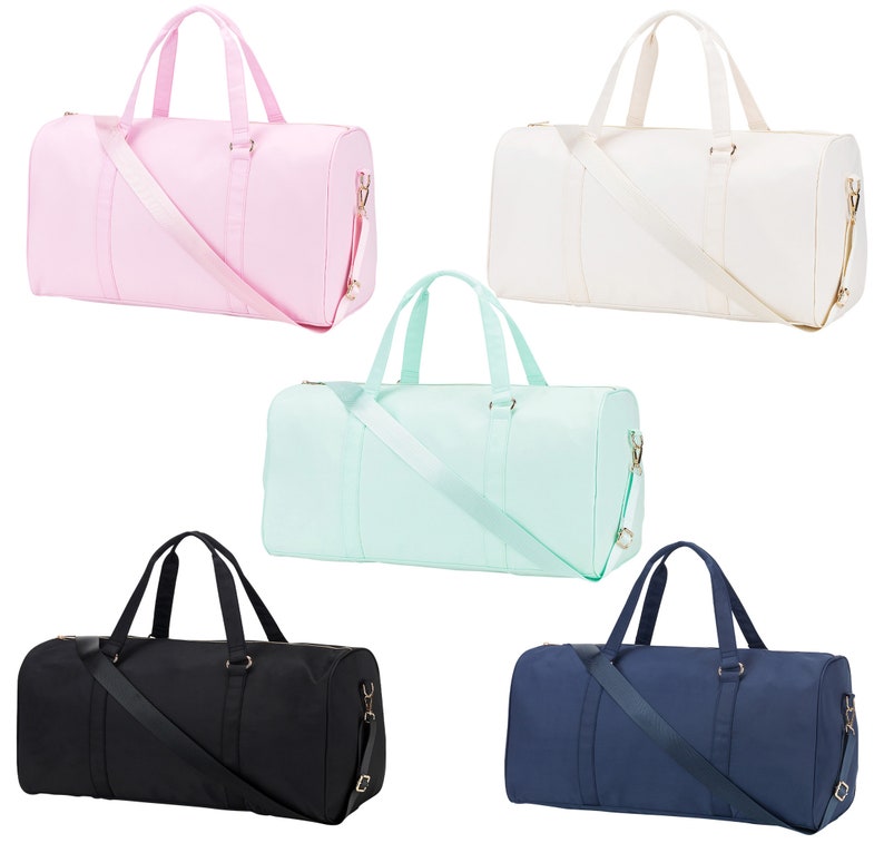 May include: Five different colored duffel bags. The bags are all the same style and size. The colors are pink, white, light blue, black, and navy blue.