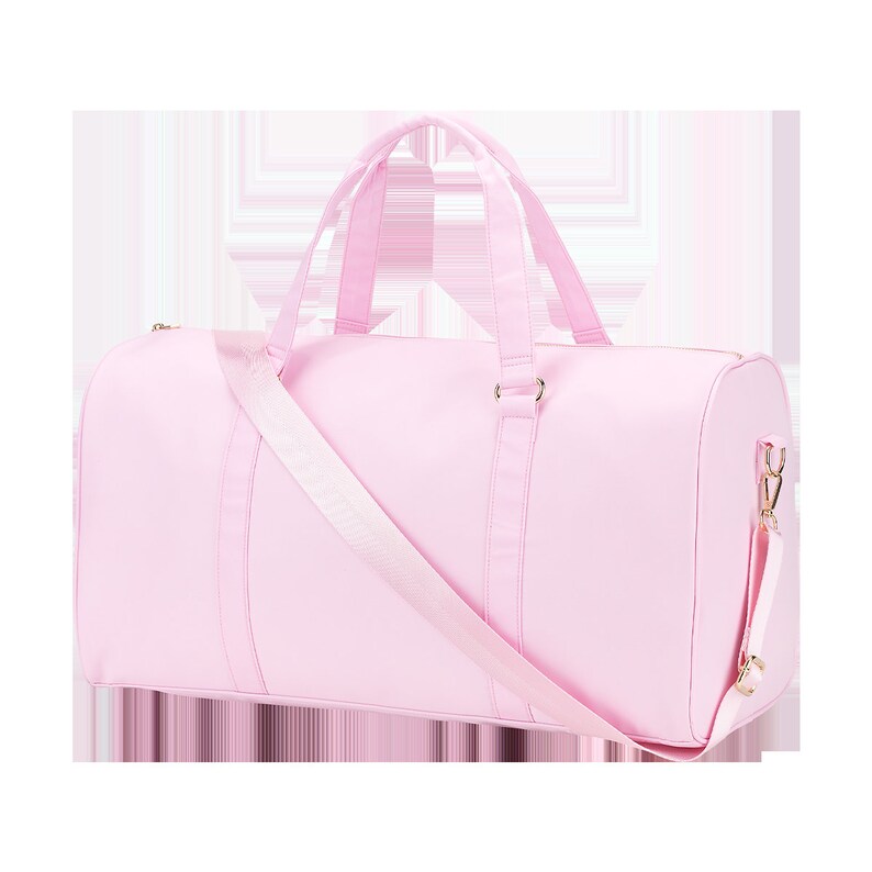May include: A light pink canvas duffel bag with a long adjustable shoulder strap and gold hardware.