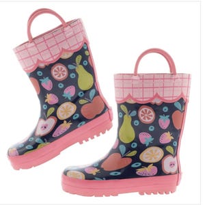 May include: A pair of navy blue rain boots featuring a colorful fruit pattern of apples, pears, strawberries, and orange slices. The boots have a pink scalloped trim with a grid pattern at the top, pink soles, and pink pull-on handles at the sides.