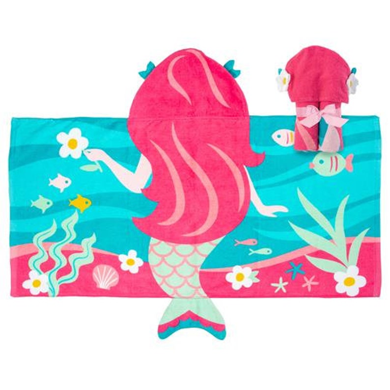 May include: A pink hooded towel with a mermaid design. The towel features a mermaid with pink hair, a green tail, and a blue and green ocean background. The towel also includes a matching hand towel.