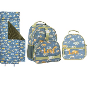 May include: A blue and yellow construction-themed kids' set, including a sleeping bag, backpack, and lunch bag. The set features a repeating pattern of trucks and construction vehicles. The name "Levi" is printed on the backpack and lunch bag.
