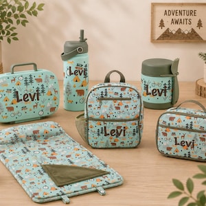 May include: A collection of camping-themed accessories in teal, including a lunchbox, backpack, water bottle, food container, and a small carrying case. Each item features a repeating pattern of tents, trees, and bears, with the name "Levi" printed on each item.