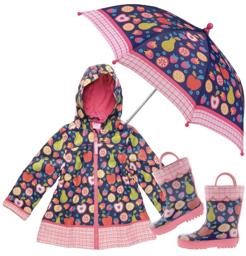 May include: A navy blue hooded raincoat, a pair of matching rain boots, and an umbrella, all featuring a colorful pattern of apples, pears, strawberries, and citrus slices, with pink plaid trim and pink accents on the boots and umbrella.