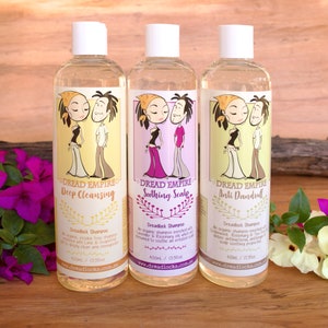 May include: Three clear plastic bottles of Dread Empire Dreadlock Shampoo. The bottles are labeled with different varieties: Deep Cleansing, Soothing Scalp, and Anti Dandruff. Each bottle has a cartoon illustration of a couple with dreadlocks.