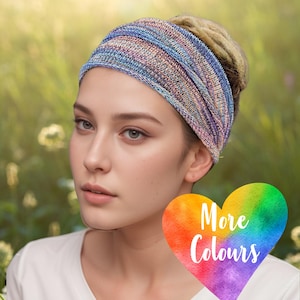 May include: A woman wearing a multi-coloured knitted headband. The headband features shades of blue, pink and purple. The headband is worn around the forehead and tied at the back of the head. The woman is wearing a white shirt. A rainbow heart with the text "More Colours" is in the lower right corner of the image.