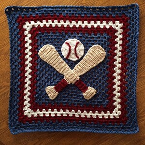 May include: A blue, white, and red crocheted blanket with a baseball and crossed bats in the center.