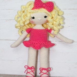 Pu&ograve; includere: Bambola all'uncinetto fatta a mano con un vestito rosa, fiocco e scarpette da ballo. La bambola ha i capelli biondi ricci e realizzata con filato color crema e rosa. La bambola &egrave; alta circa 30 cm.