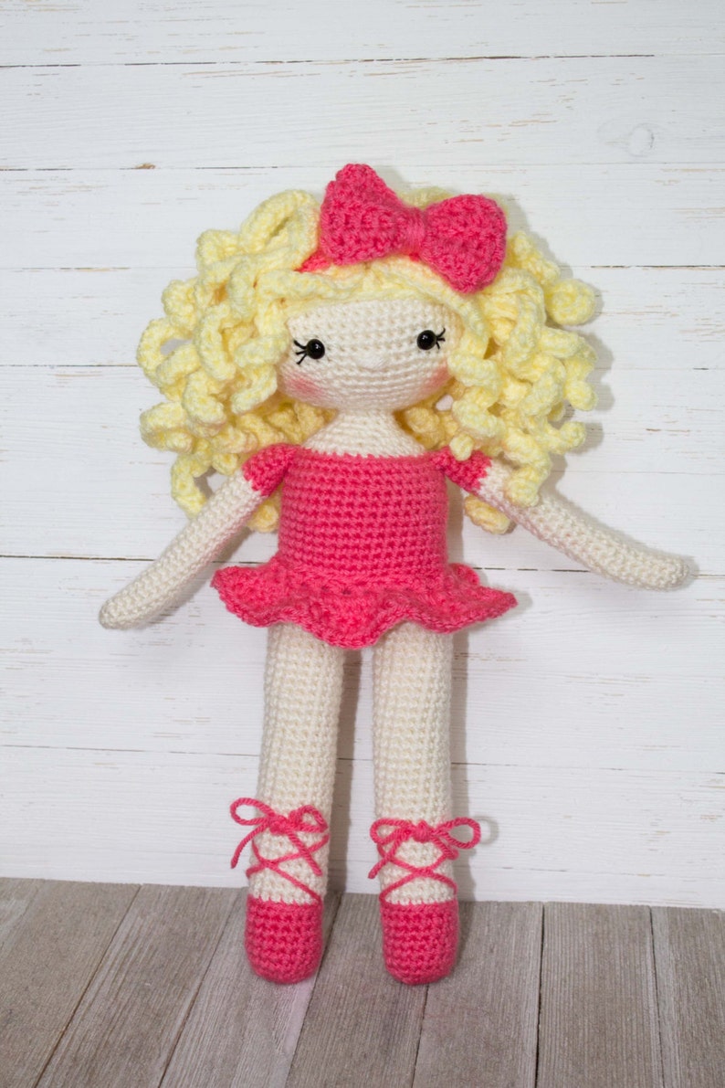 Pu&ograve; includere: Bambola all'uncinetto fatta a mano con un vestito rosa, fiocco e scarpette da ballo. La bambola ha i capelli biondi ricci e realizzata con filato color crema e rosa. La bambola &egrave; alta circa 30 cm.