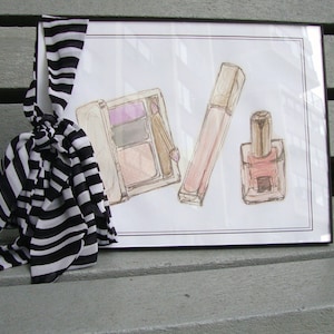 May include: A framed illustration of makeup products, including a pink and white eyeshadow palette, a pink lip gloss, and a clear bottle of nail polish with a pink cap.