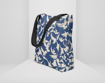 May include: A blue and white tote bag with a pattern of flying birds. The bag has black straps.