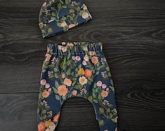 Conjunto orgánico para bebé: pantalón harem floral y gorro con nudo.