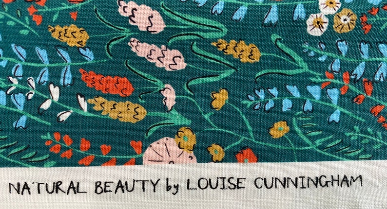 May include: A teal fabric with a floral pattern featuring various flowers in shades of pink, orange, yellow, and blue. The fabric has the text "NATURAL BEAUTY by LOUISE CUNNINGHAM" printed at the bottom.