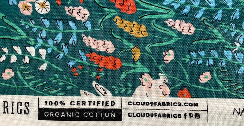 May include: Teal fabric with a floral pattern featuring pink, white, orange, and blue flowers. The fabric has a label that reads "100% Certified Organic Cotton" and "Cloud9Fabrics.com".