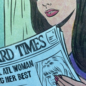 Puede incluir: Una mujer con el pelo largo y negro lee un peri&oacute;dico con el titular "HARD TIMES" y el subt&iacute;tulo "LOCAL ATL WOMAN DOING HER BEST".