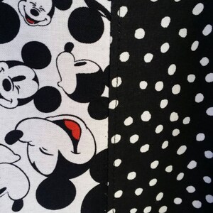 May include: Close-up of fabric with a split design. One side features a white background with black Mickey Mouse faces. The other side has a black background with white polka dots. The text "4girlsbags" is on a small label.