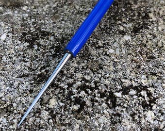 May include: A blue handled tool with a long, thin, pointed metal tip. The tool is used for crafts and hobbies.