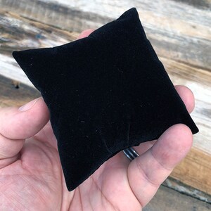 May include: A black velvet pillow for displaying jewelry or other small items.