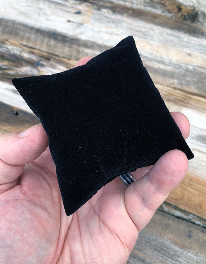 May include: A black velvet pillow for displaying jewelry or other small items.