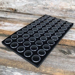May include: Black foam storage tray with 64 clear plastic compartments for organizing small items.