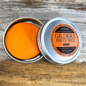 May include: A small tin of orange Gilders Paste Wax. The label reads "Gilders Paste Wax Orange" and "Covers over 30 sq ft - 2.78 sq m. Net 1 oz - 30 ml by volume."