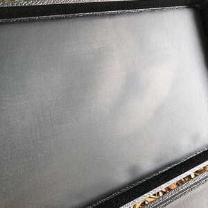 K&ouml;nnte beinhalten: Schwarze rechteckige Box mit weicher schwarzer Stoffauskleidung. Die Box hat einen silbernen Verschluss.