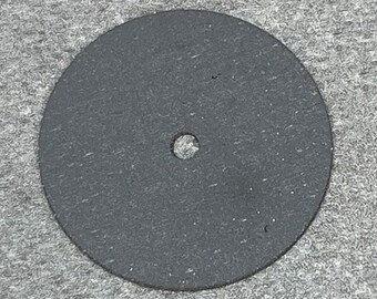 May include: A black, round sanding disc with a small hole in the center.