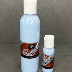 May include: Two bottles of Fabulustre leather conditioner. The larger bottle is blue with a white cap and a label that says "New Paste! Fabulustre High Lustre! Leaves a Bright & Thin Protective Film. Net Weight 8 oz.". The smaller bottle is also blue with a white cap and a label that says "Fabulustre High Lustre! Leaves a Bright & Thin Protective Film. 2 fl oz."