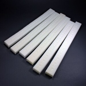 May include: Eight white foam strips with adhesive backing. The strips are about 12 inches long and have a textured surface.