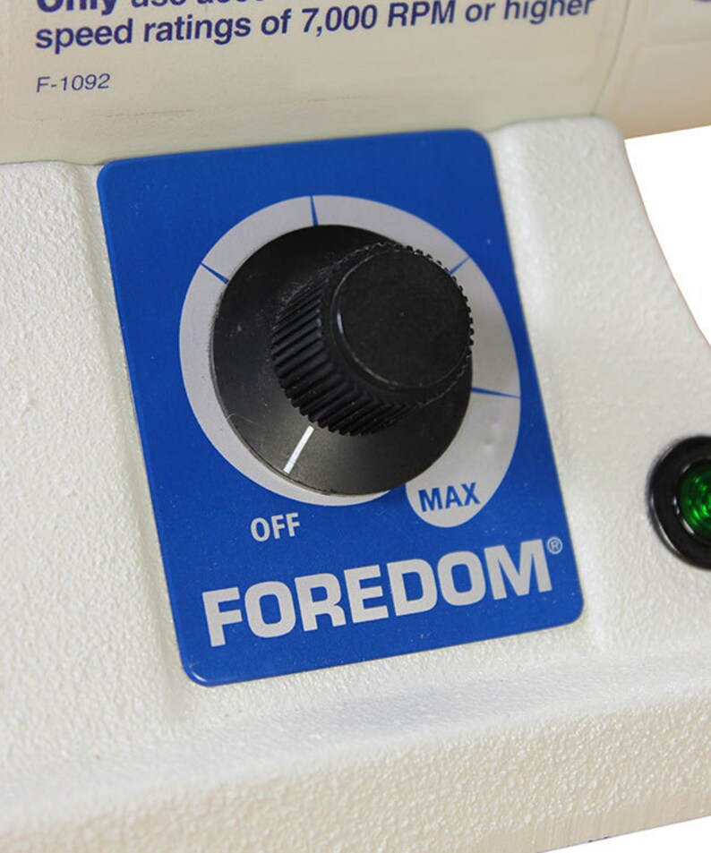 Może przedstawiać: Niebieski panel sterowania z pokrętłem, kt&oacute;re można obracać, aby regulować prędkość narzędzia obrotowego Foredom. Pokrętło jest oznaczone jako "OFF" i "MAX".