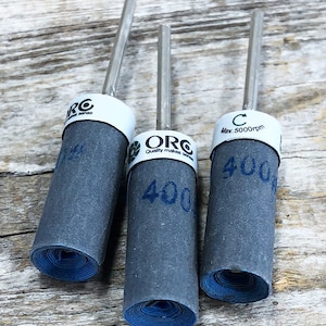 Może przedstawiać: Trzy szare bębny szlifierskie z niebieskimi krawędziami i srebrnym metalowym wałem. Bębny są oznaczone tekstem "ORC Quality makes sense" i "400". Trzeci bęben jest oznaczony "C Max. 5000rpm" i "400".