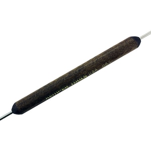 May include: A Kemper Tools USA DB3 double-ended clay sculpting tool. The tool has a dark brown wooden handle with a metal tip on each end. One end has a small ball, and the other has a pointed tip. The tool is designed for sculpting and detailing.