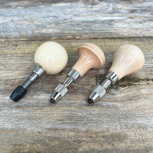 May include: Three wooden handled tools with metal shafts and tips. The tools have different shaped handles, one is round, one is a short cylinder, and the other is a longer cylinder.
