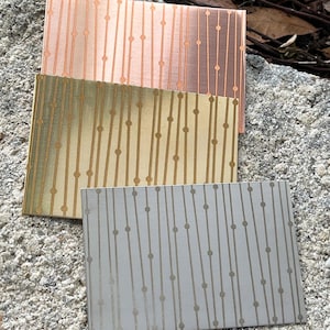 May include: Three decorative cards with a vertical striped pattern and small circles. The cards are in shades of peach, green, and gray.