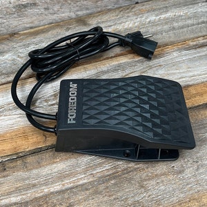 Puede incluir: Pedal de pie negro con un patr&oacute;n de diamante en la parte superior. El pedal tiene un cable negro con un enchufe europeo. El texto "FOREDOM" est&aacute; impreso en el lateral del pedal.