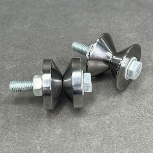 May include: Two silver metal roller wheels with a threaded bolt and nut. The wheels are designed to be used on a surface to help move heavy objects.